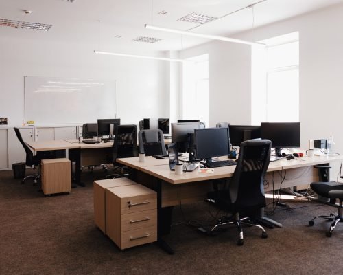 IT open space office. Computer Work Stations. Office Workplace with windows.